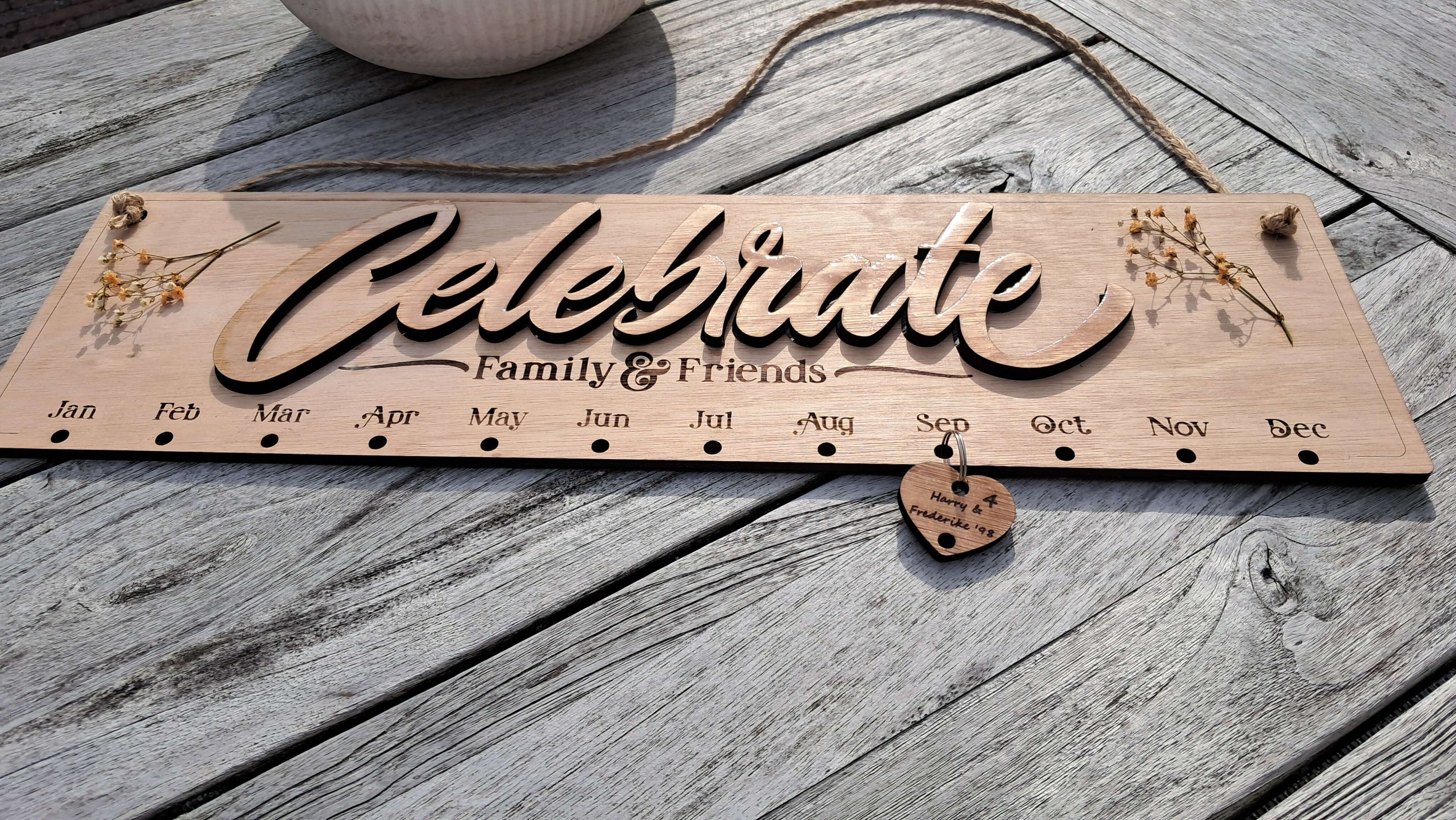 Verjaardagskalender van hout, gegraveerd met maanden en een decoratieve design voor familie en vrienden.