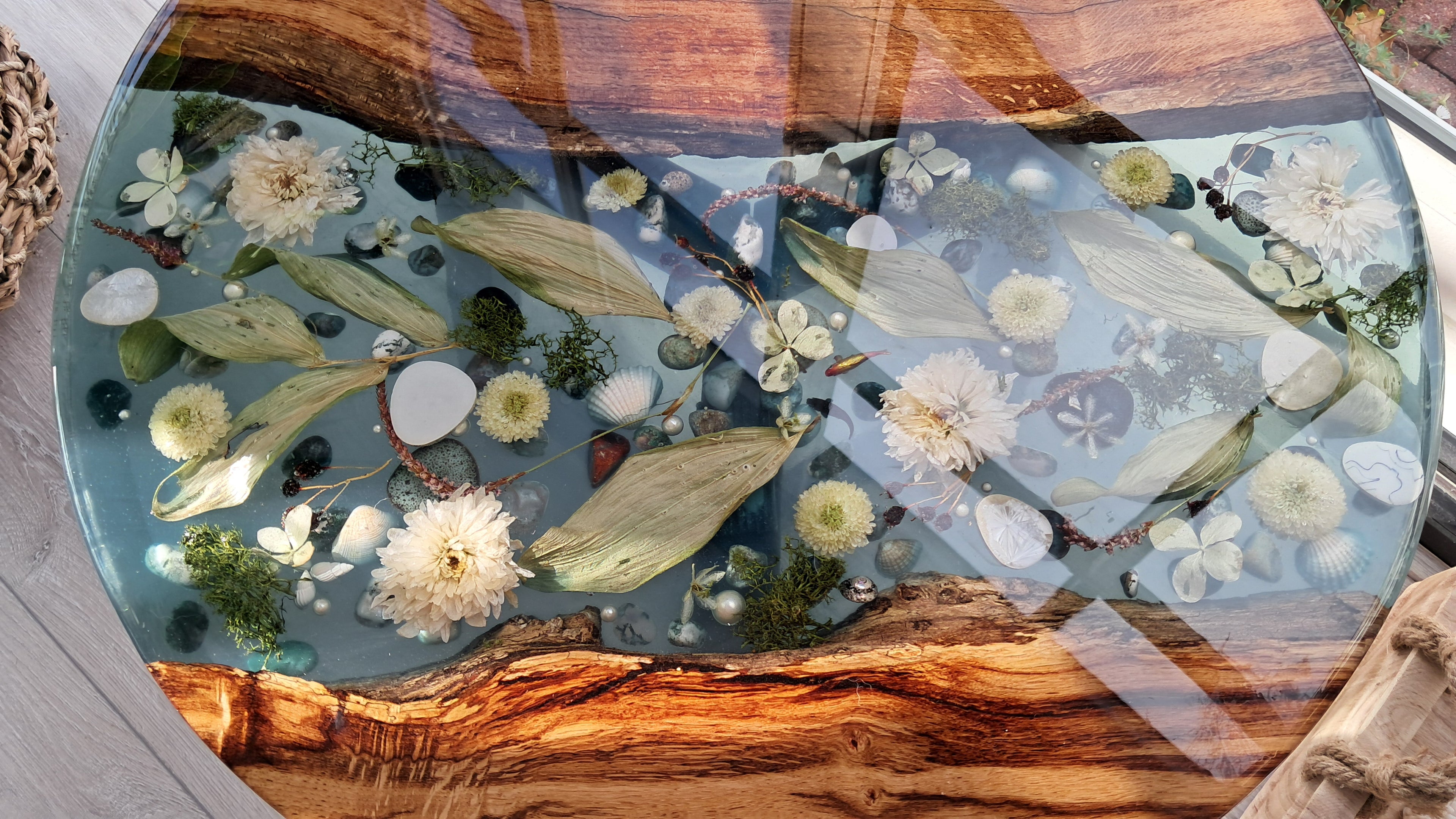 Epoxy tafel Rivier met bloemen, bladeren en steentjes in Amerikaans eikenhout, diameter 49cm.