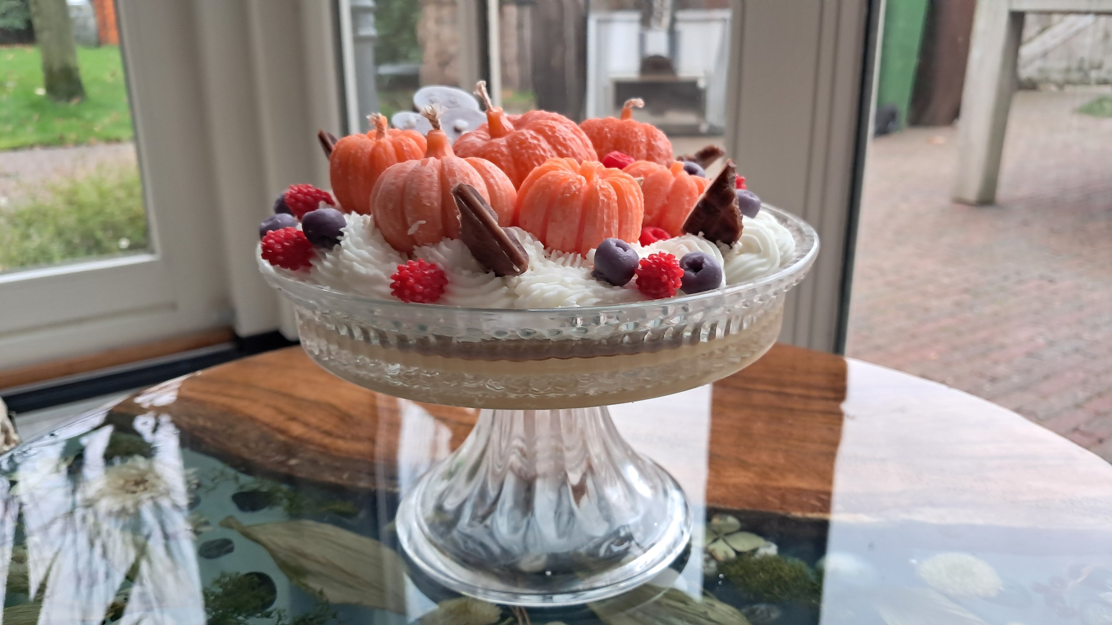 Geurtaart Kaars – Luxe kaarsentaart met pompoentjes, fruit & slagroom, gepresenteerd op glazen plateau.