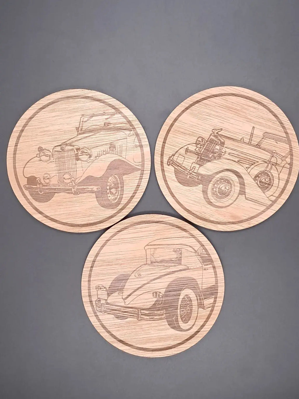 Klassieke Auto Onderzetter Set met gegraveerde ontwerpen van klassieke auto’s op houten onderzetters.